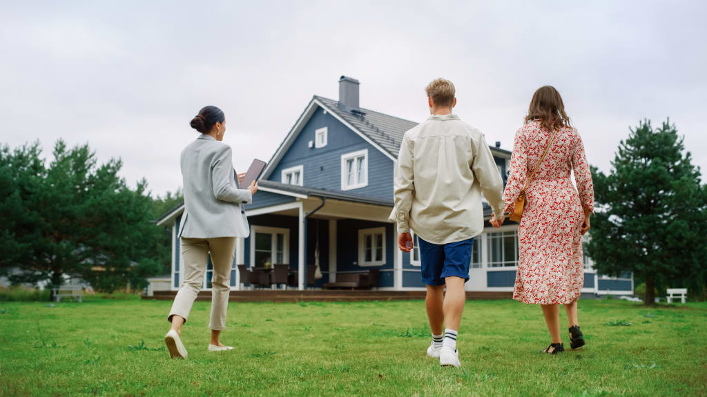 Couple in front of their property thinking of selling their main residence