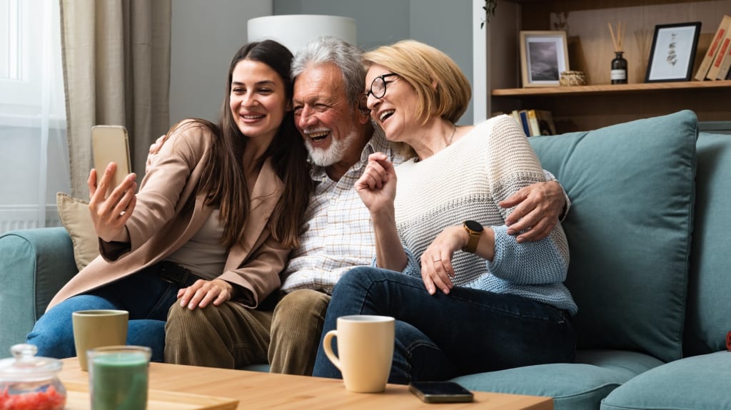 Grands-parents qui prennent une photo avec leur petite-fille dans leur propriété