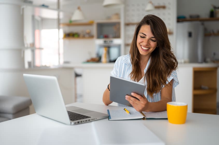 Smiling woman using a digital tablet at home